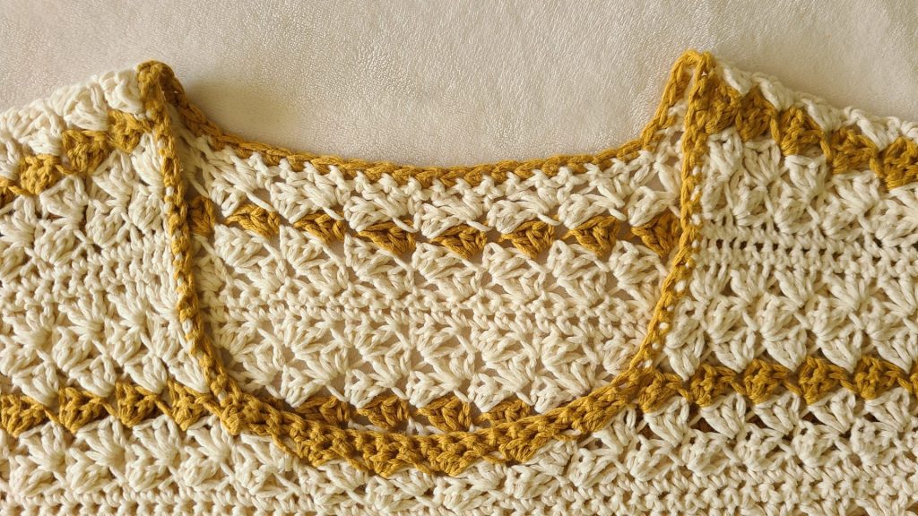 Yellow-beige striped crochet sweater, close-up on neck and shoulders."