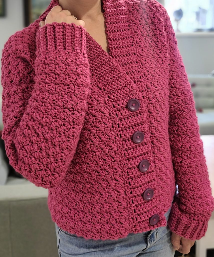 pink crochet cardigan worn by a woman