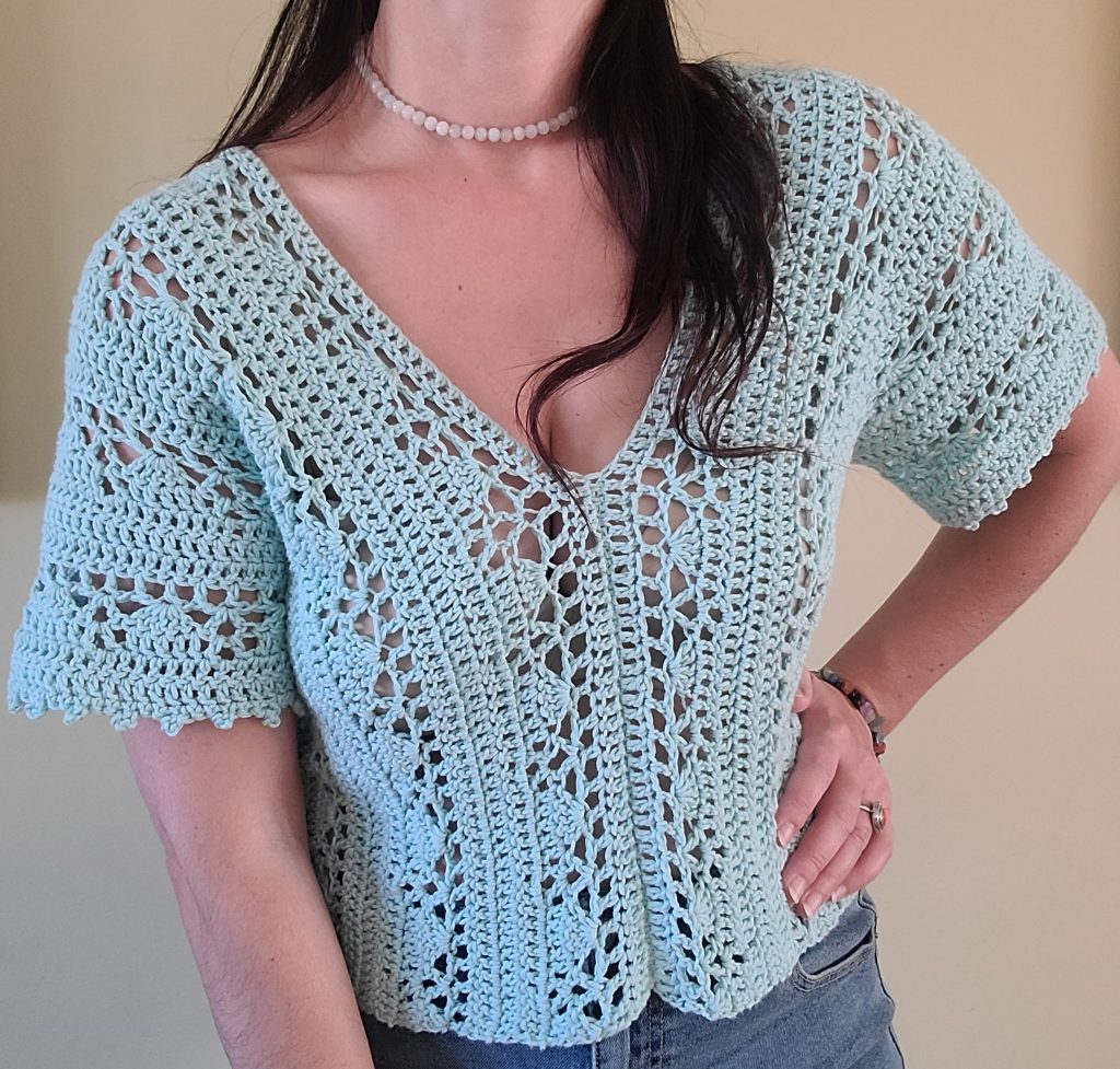 Woman wearing the Gina Crochet Lace Top made with a delicate cream lace crochet stitch.