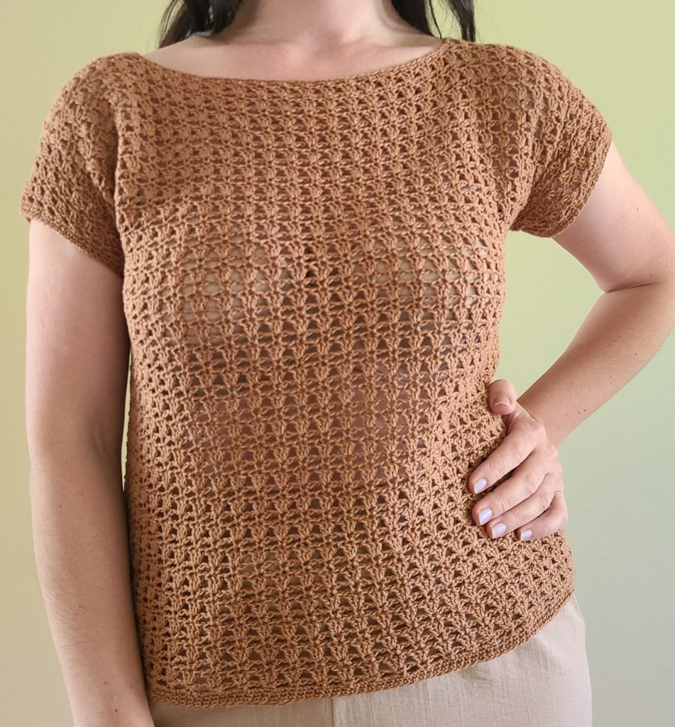 crochet brown top worn by a woman on a neutral brackground