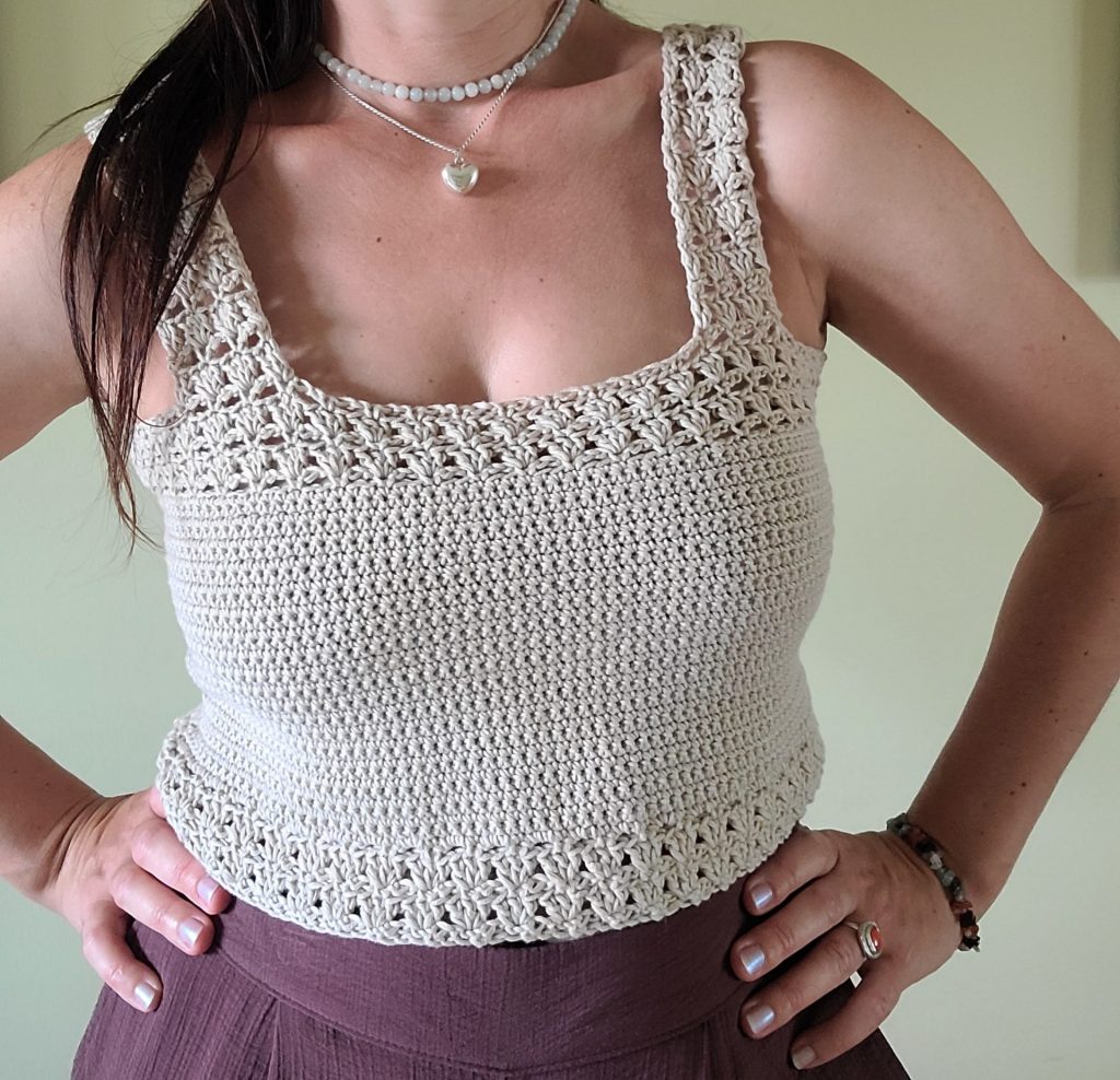 crochet grey crop top worn by a woman on a neutral background