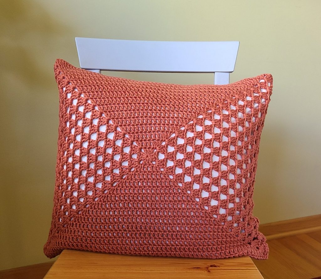 orange granny square pillow cover on a chair