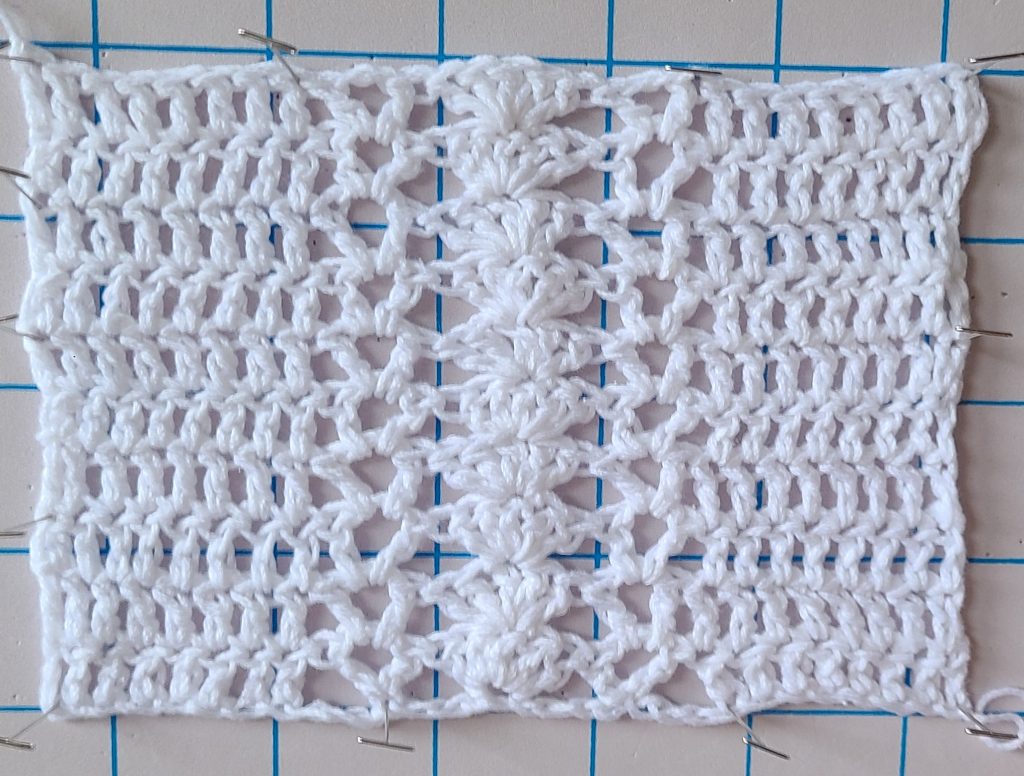 Close-up of crochet square lace stitches showing gauge measurement