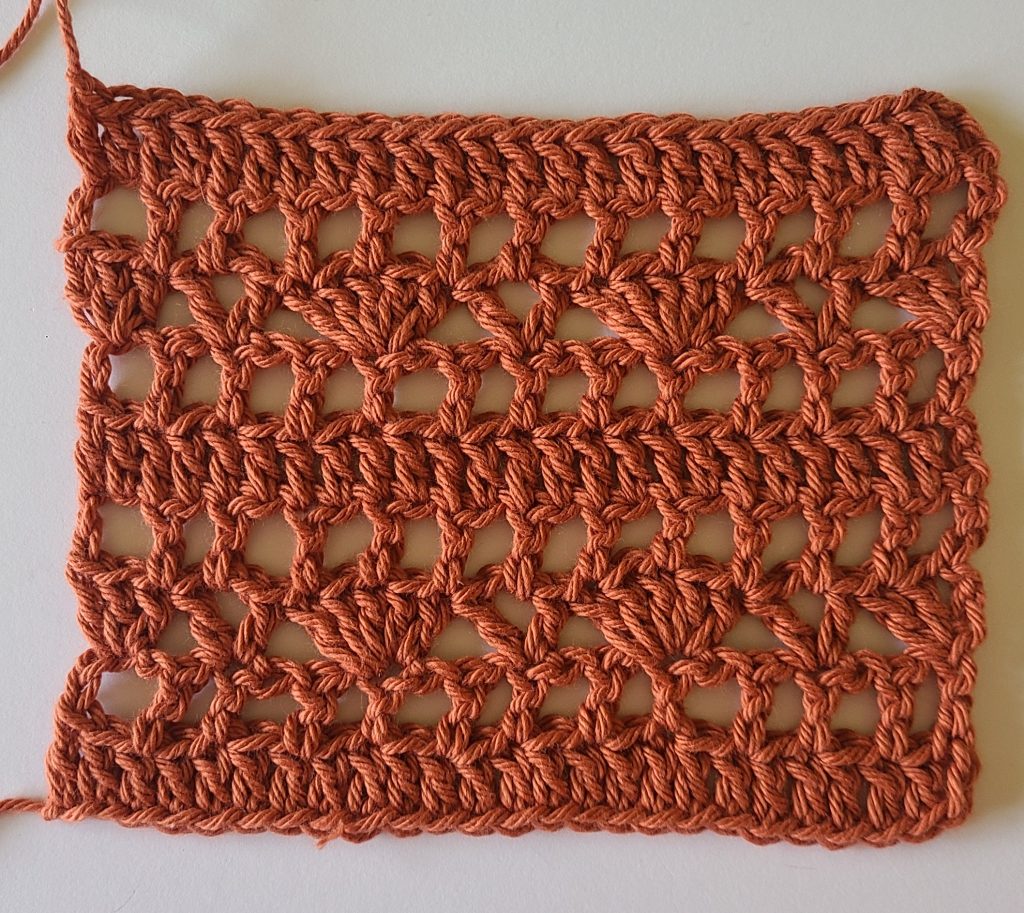 Close-up of the crochet gauge swatch used for the Lamelya Crochet Lacy Top, displaying the lace stitch pattern and measurement guide.