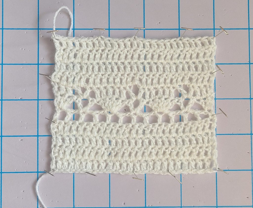 Crochet gauge swatch showing lace stitch pattern measured for a crochet lacy sweater
