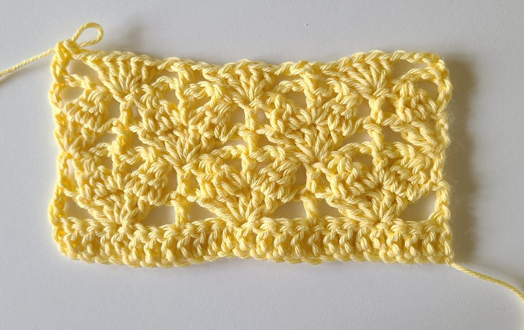 Close-up of yellow crochet gauge swatch showing textured stitch pattern for the Lorelay crochet crop top.
