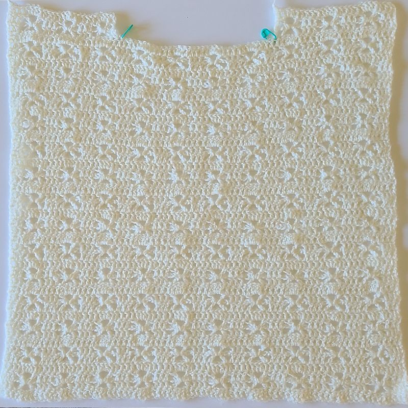 Front panel of crochet lacy sweater with neckline shaping in progress