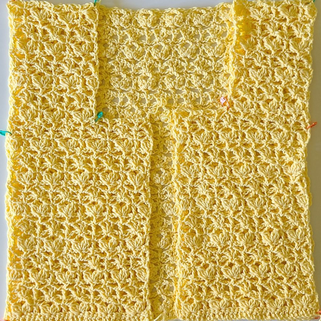 crochet vest panels being assembled with stitch markers