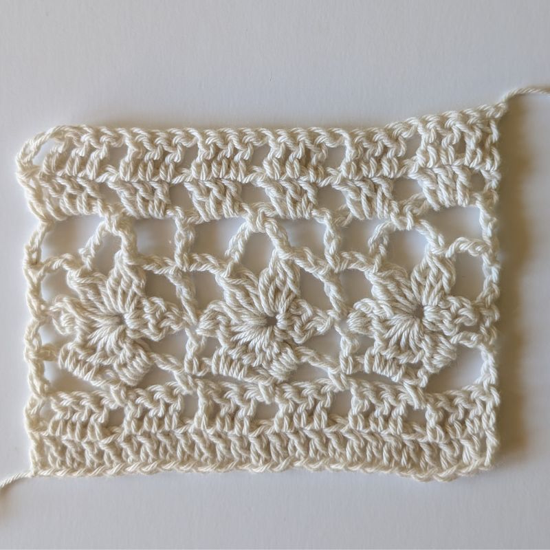 Crochet swatch for the Della Crochet Lace Top showing the six-row flower lace stitch pattern worked in DK cotton yarn.