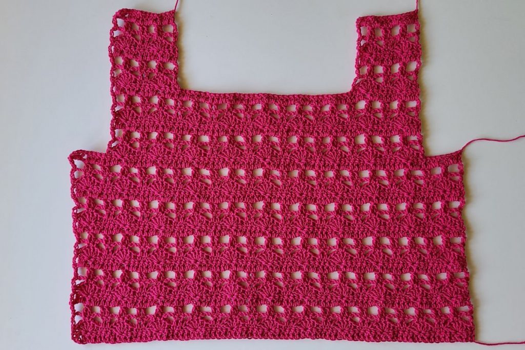 Back panel of the Myla Crochet Lace Crop Top showing the completed armhole and strap shaping worked in an open shell stitch pattern.