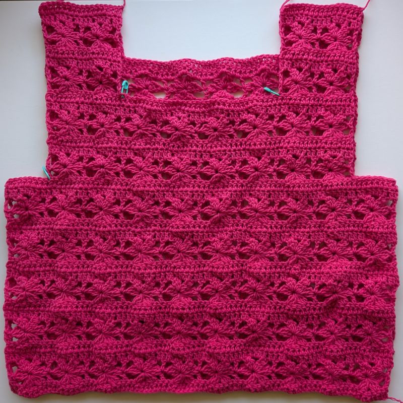 Front and back crochet top panels aligned with stitch markers before seaming the shoulders and sides.