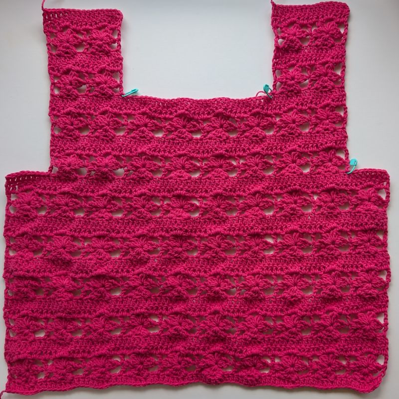 Front panel of the Zana Crochet Top showing the square neckline, armhole shaping, and floral stitch pattern.