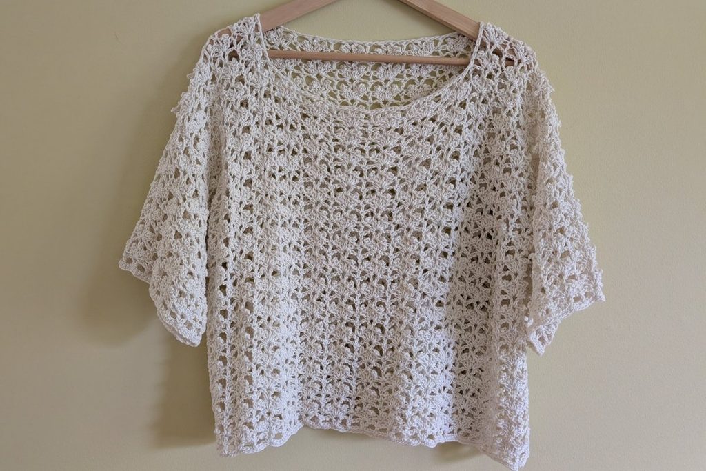 Finished top hanging to show its lace stitch pattern and relaxed shape
