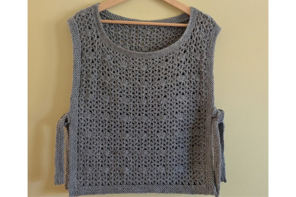 Finished gray crochet sweater tie-vest laid flat